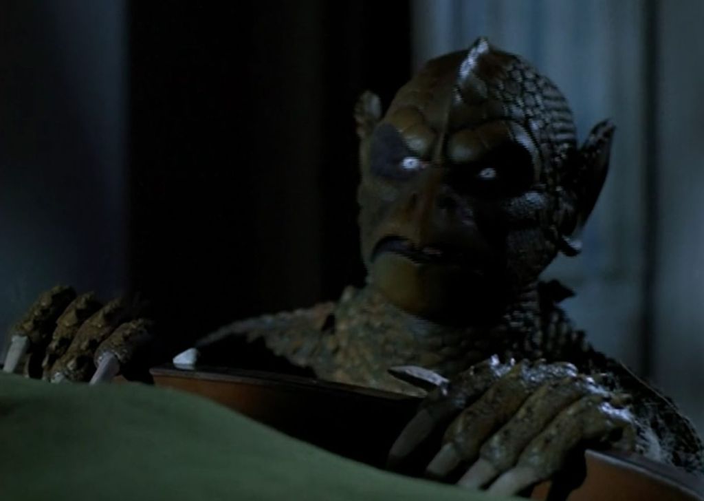 A gargoyle lurking at the bottom of the bed!