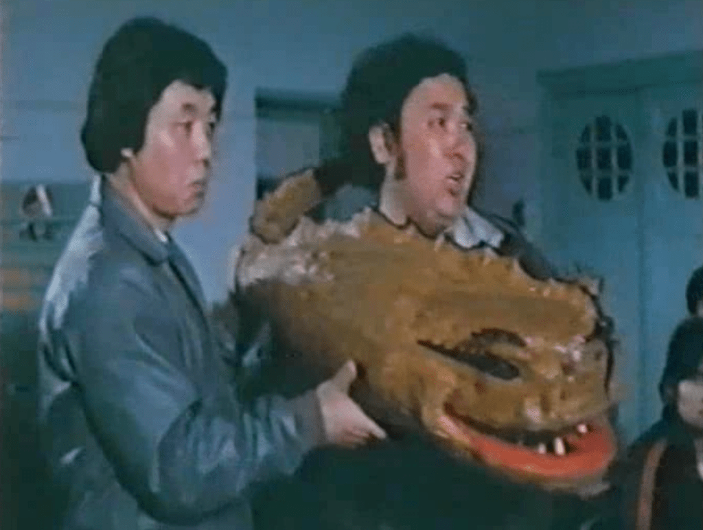 Characters in the movie show off a model of what they think the terrifying snake monster might look like...