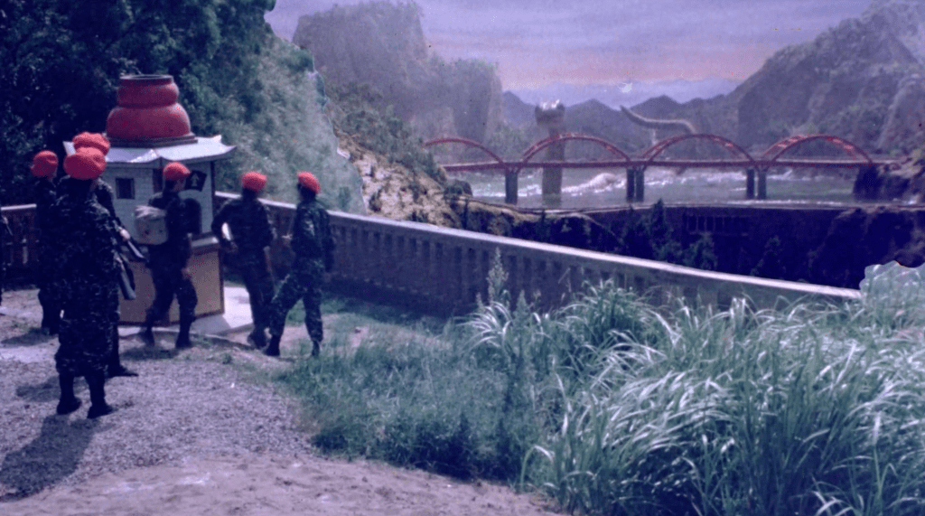 The army watches as Mosler approaches a bridge
