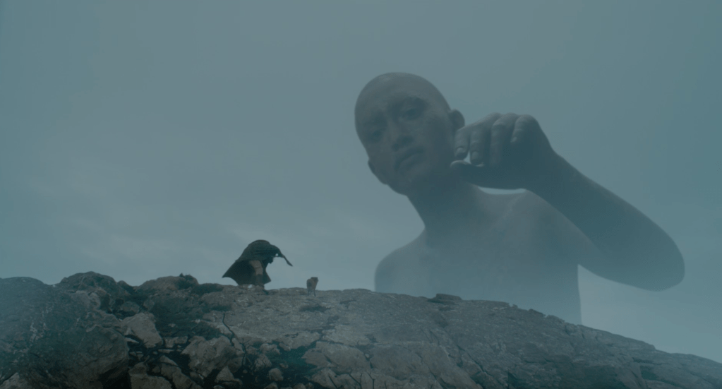 A giant reaches out towards Gawain...