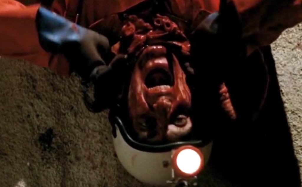 The dude's hanging upside down with the alien blob around his neck...