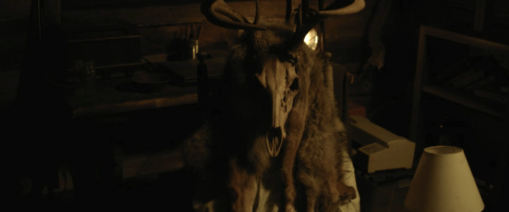 A skull adorned figure in Adam's cabin