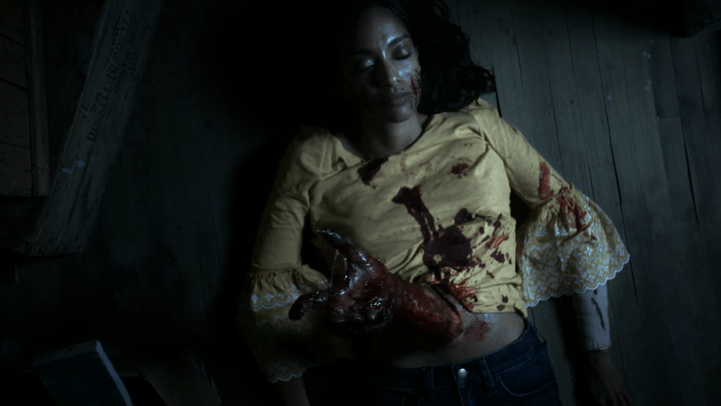 The witch's arm bursts from Sara's corpse!