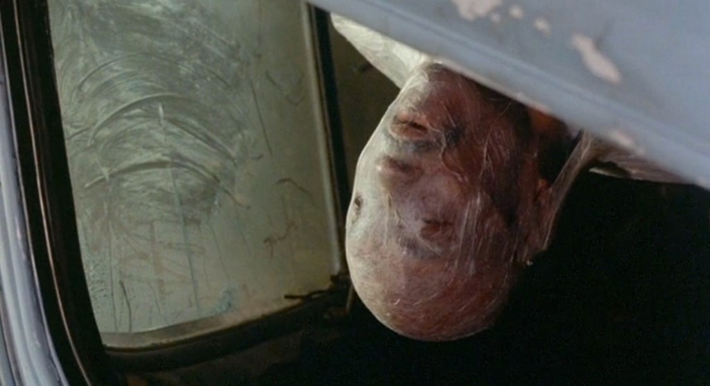 Woody Strode's cocooned body is discovered in his crashed truck