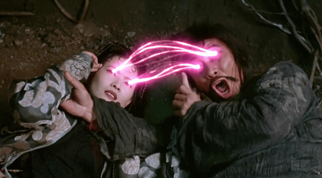 Spider Devil (Yammie Lam) accidentally uses her 'seductive magic' on the buffoonish Assistant Master (Man-Tat Ng)