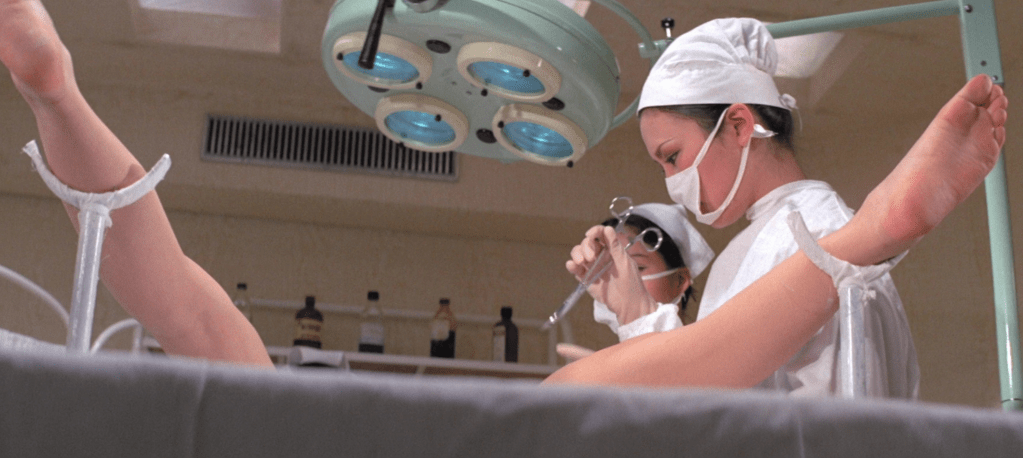 A hymen-replacement operation that will soon be interrupted by the Oily Maniac!