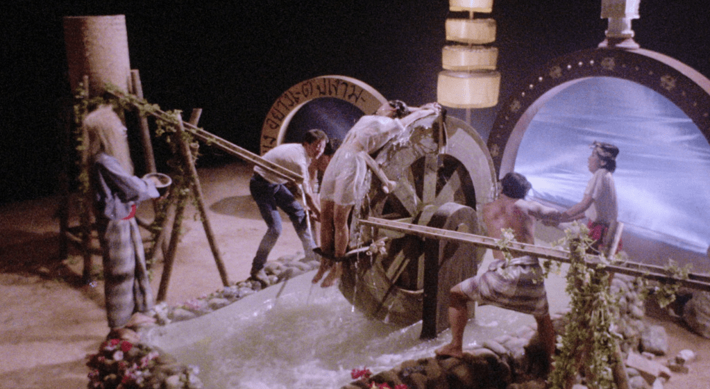 As part of the exorcism process, Stella is strapped to a revolving water wheel...