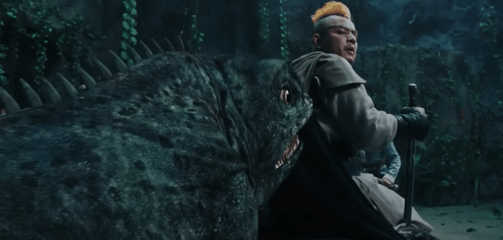 The big lizard sneaks up behind the one-eyed, hunchback warrior