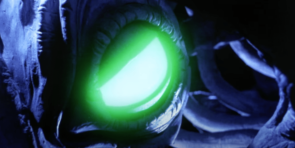 The gargoyle's glowing green eye opens