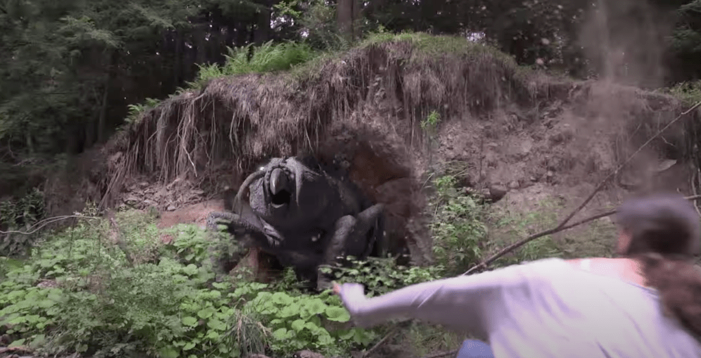 A bug-faced beast bursts from a dirt bank!