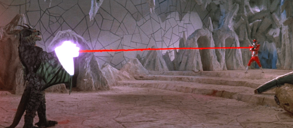 Inframan changes tactics: he fires his Thunder Fist gloves at Dragon-Elzebub, then melts her with some hand-fired laser beams!