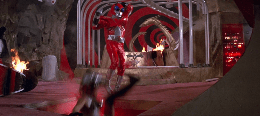 ...and Inframan kicks the villainess into a lava pit!