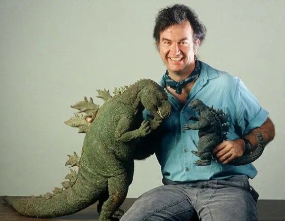 Stephen Czerkas posing with his large Godzilla stop-motion puppet and a Godzilla toy