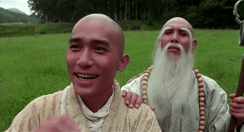 A smiling monk (Leung) and his master