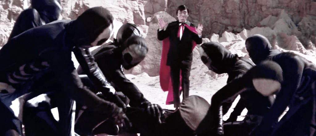 The henchmen pin Bruce to the floor and Dracula approaches...