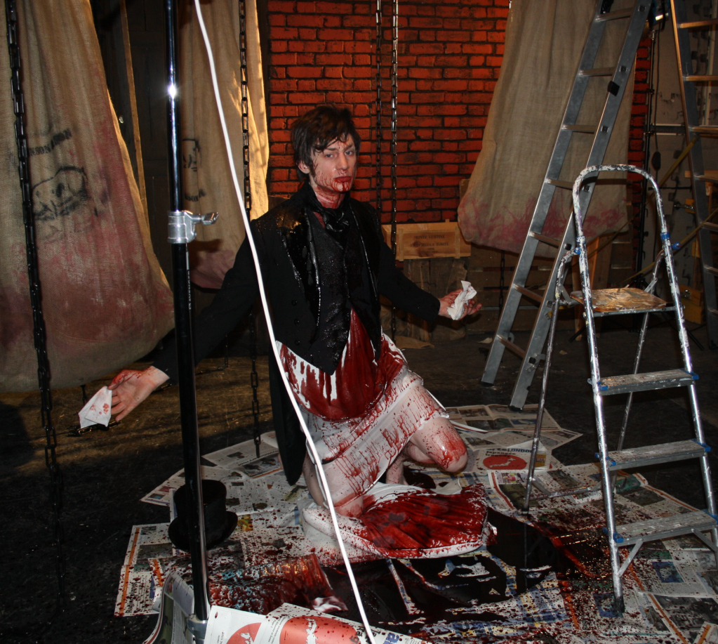 A behind the scenes shot of Andrew Mullan filming the scene where he bathes in a victim's dripping blood