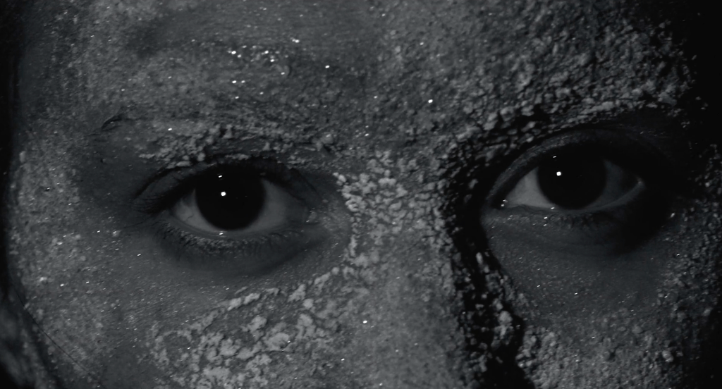 A close-up shot of the sand-speckled face of the captured Sea Maiden