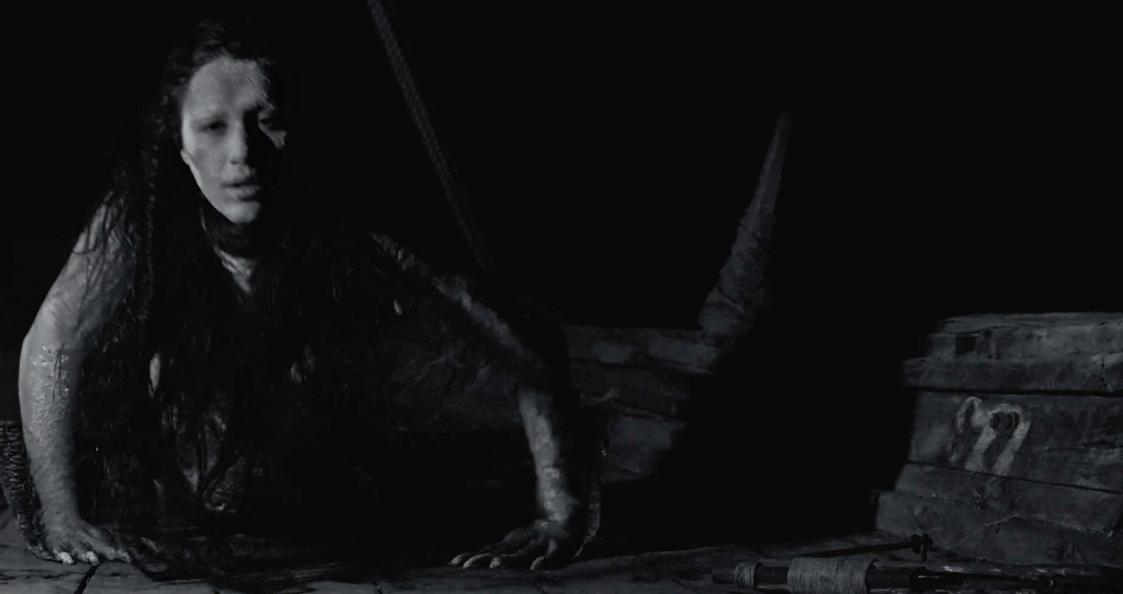 A Sea Maiden is caught and dragged onto a fishing boat, where she starts to crawl along the deck..