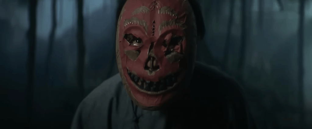 A villager wearing a ceremonial mask