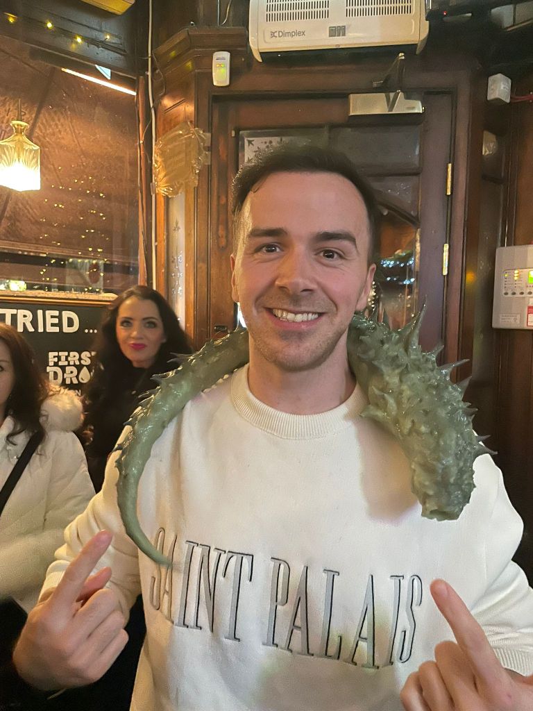 Cast member Tyler Winchcombe poses with a BONE KEEPER prop tentacle in a pub after the cast & crew screening!