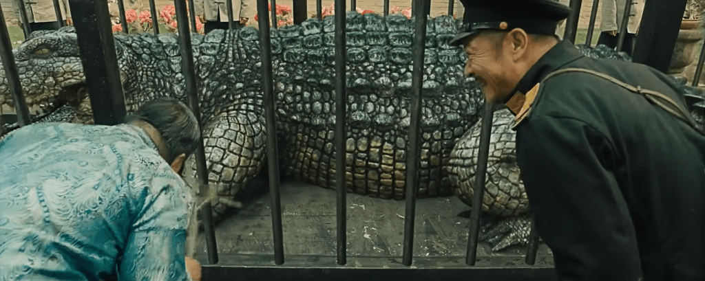 Captain Hu gives the captured male croc to Mr. Ren and his son as a gift to curry favour